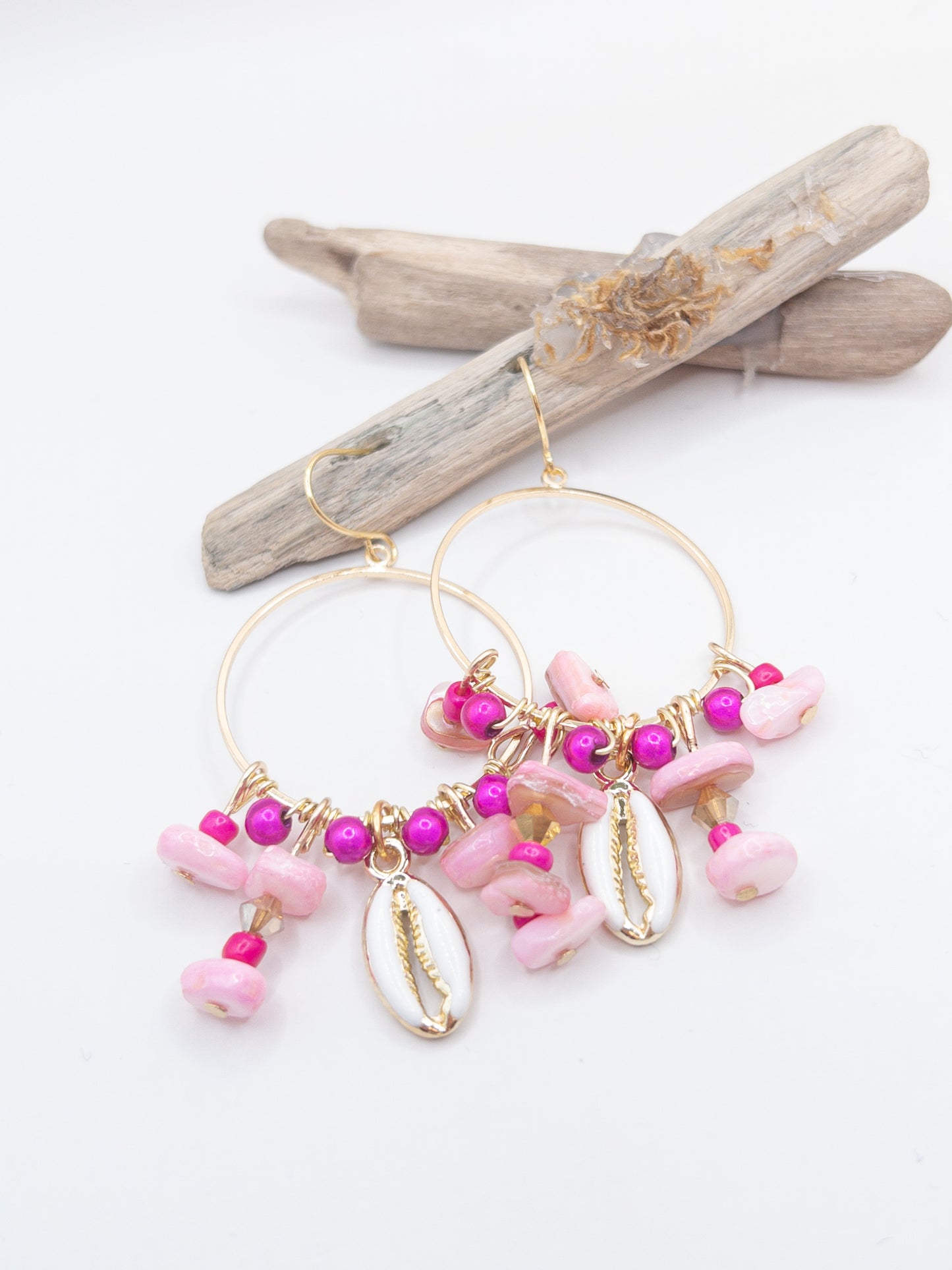 Oorbellen goud een cirkel met een schelp hanger en roze schelp kraaltjes.