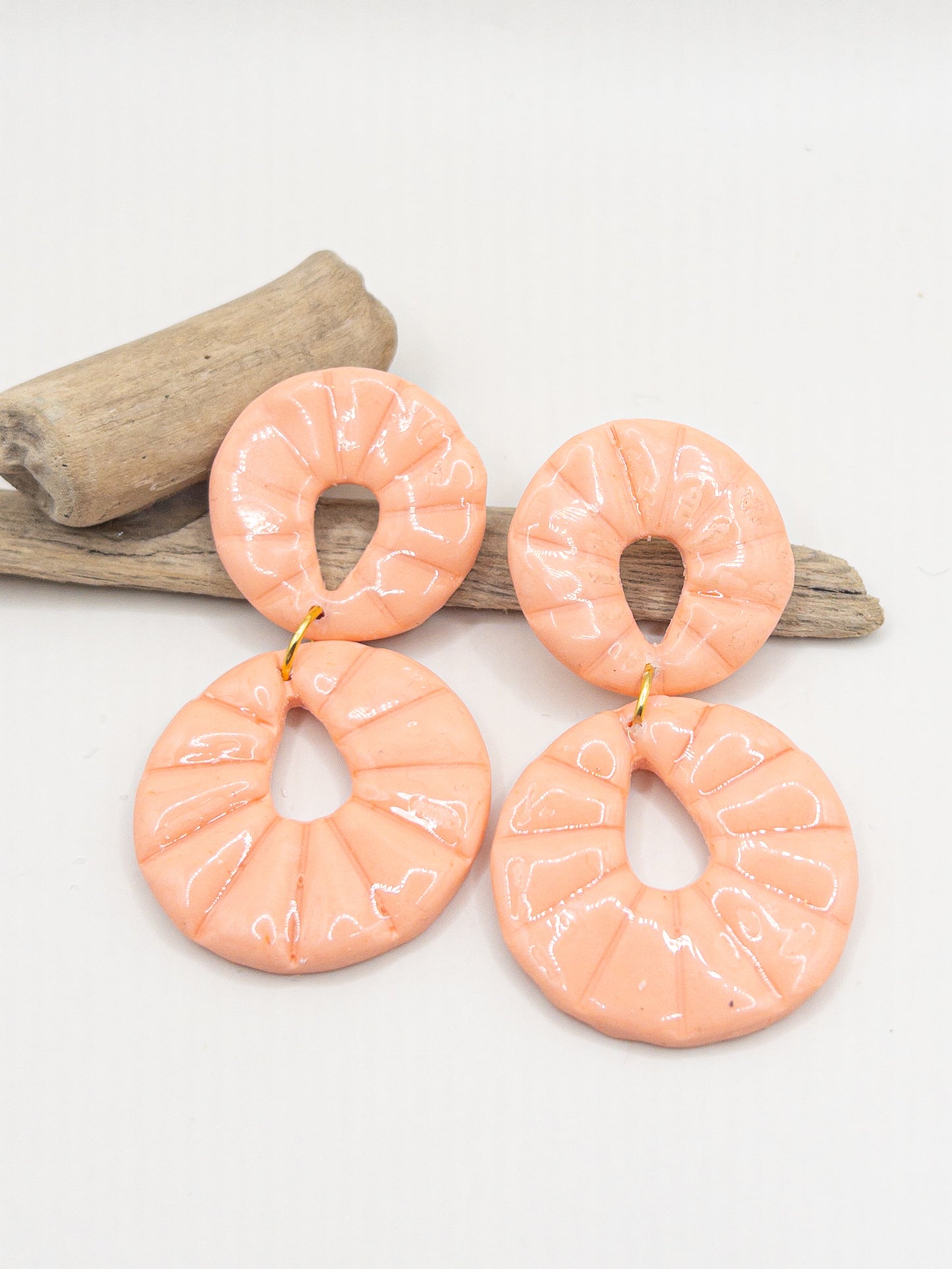 Oorbellen in perzikkleur met een ronde oorsteker en hanger met glans
