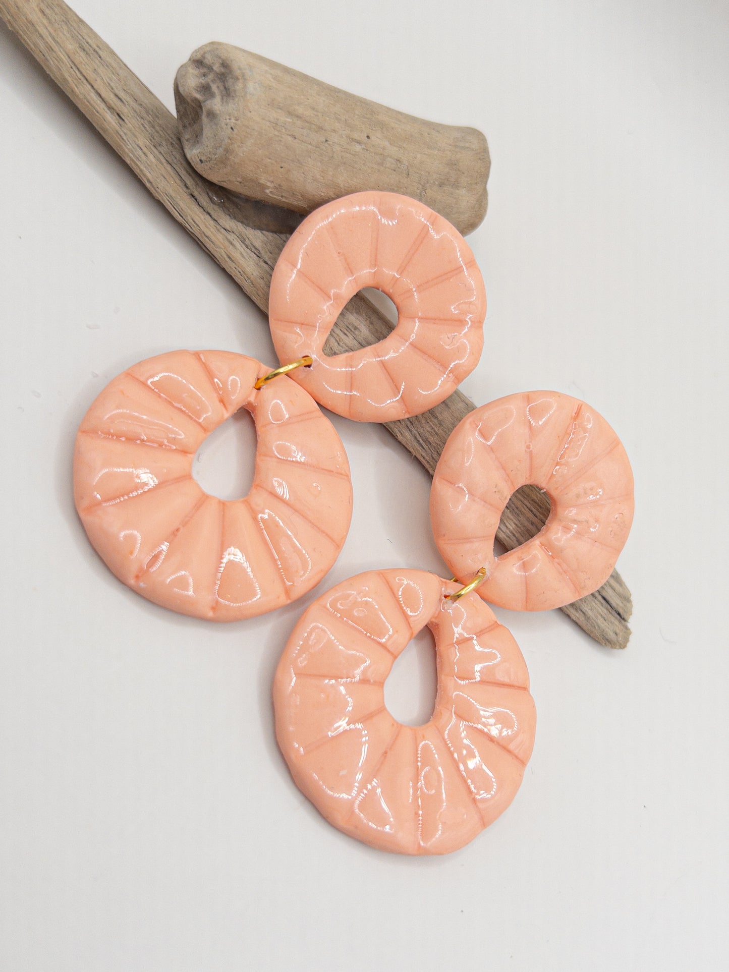 Oorbellen in perzikkleur met een ronde oorsteker en hanger met glans