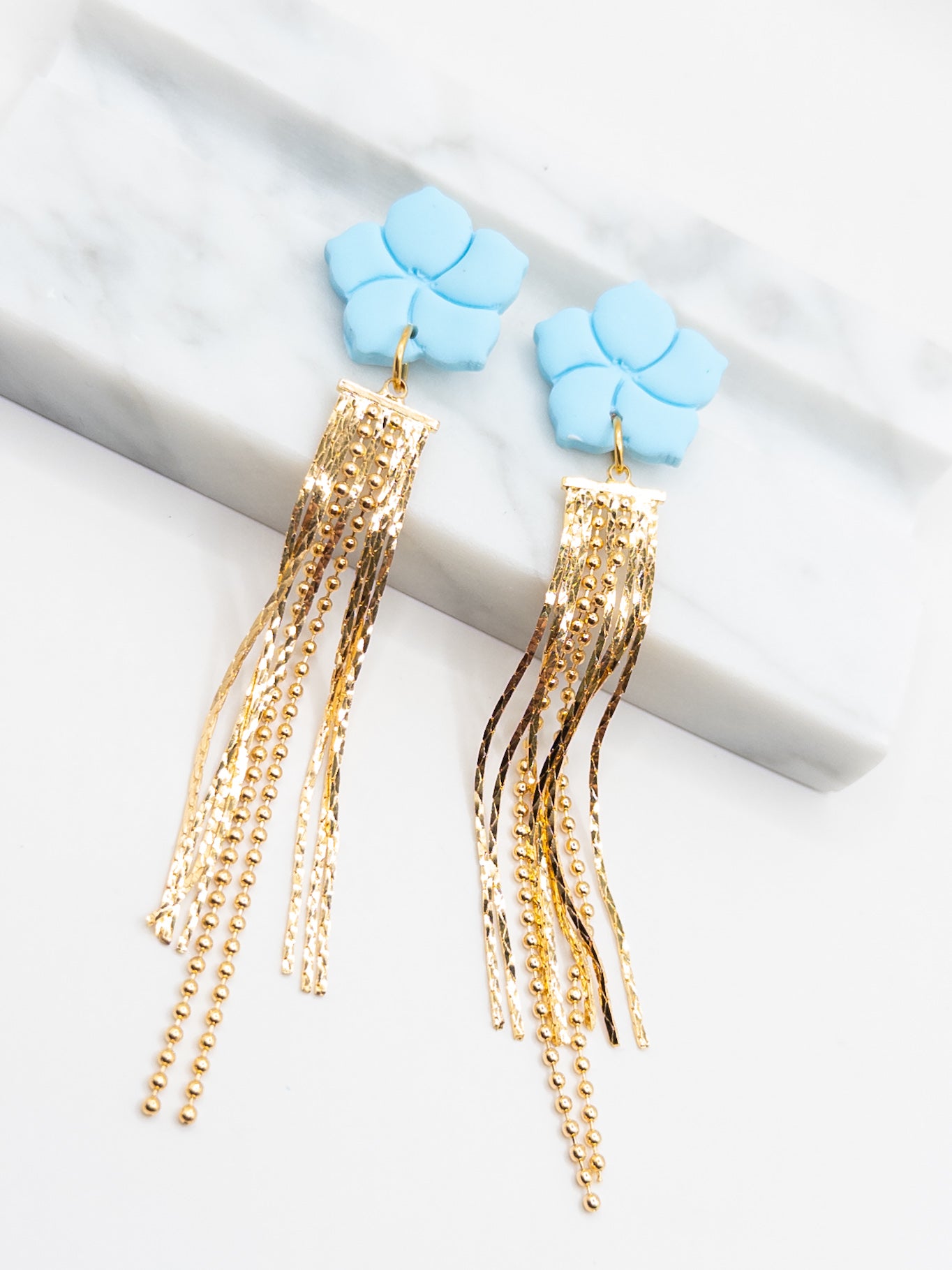 Oorbellen blauw goud bloem statement